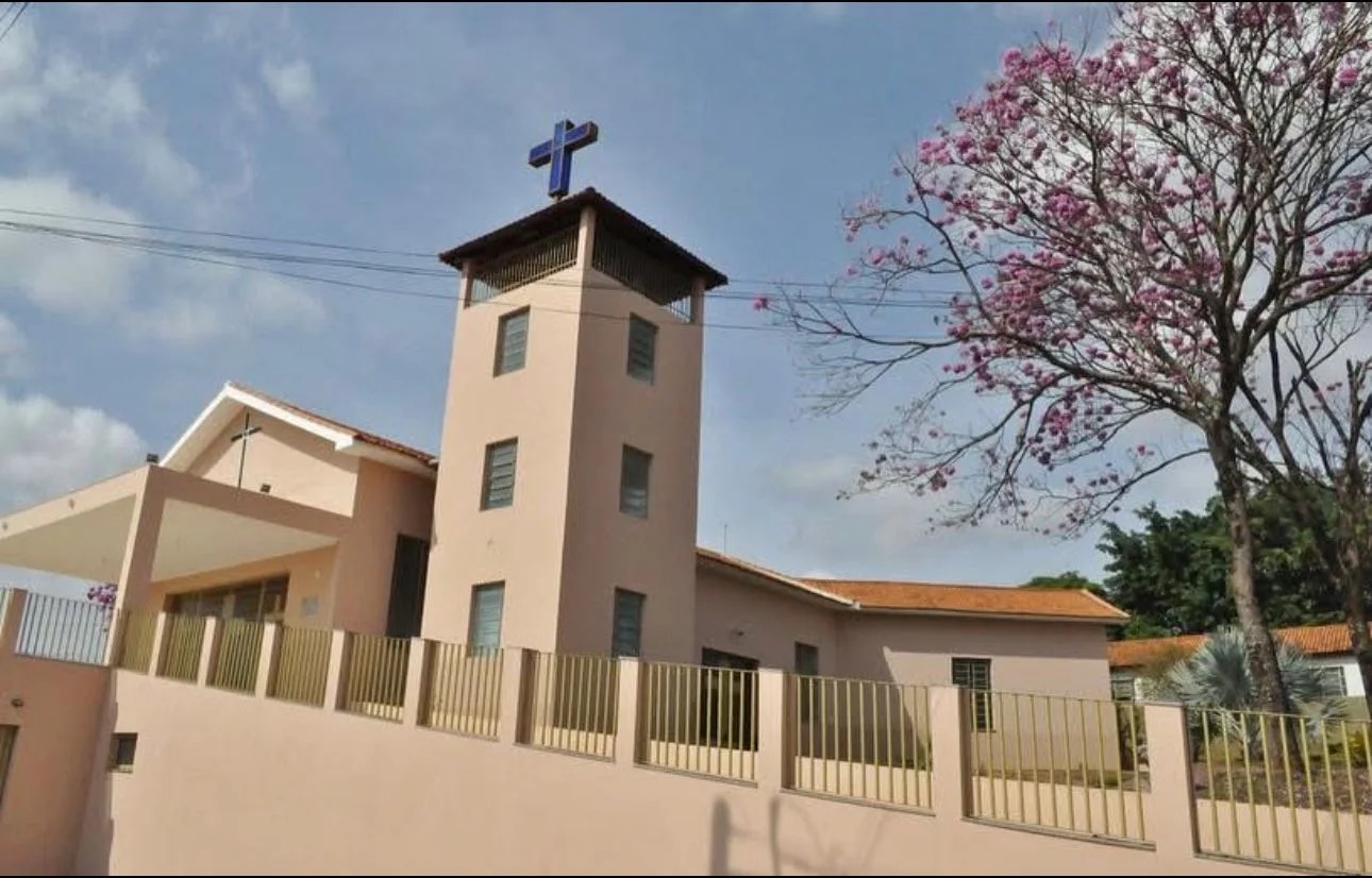 Torre e lateral da Igreja Matriz com árvore florida